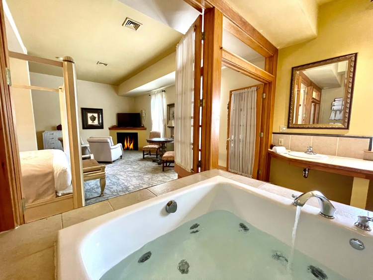 Whirpool tub in room with living space with fireplace