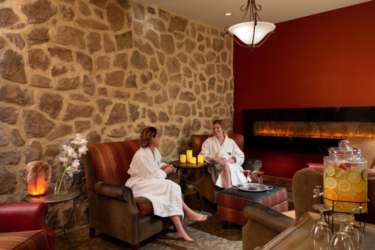 Girls sitting in bathrobes on chairs by fireplace
