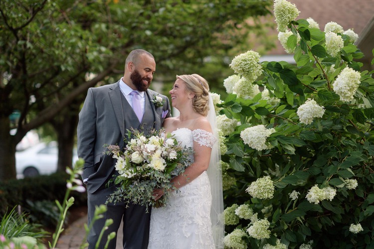 Wedding couple posing next to flowers
