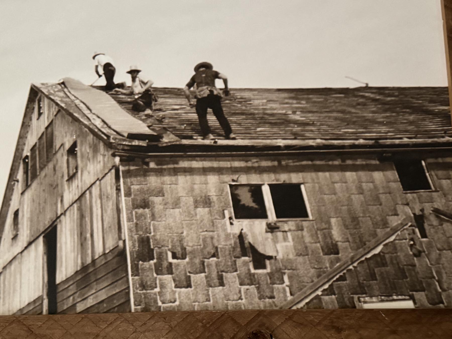 Historic photo of home with person on roof
